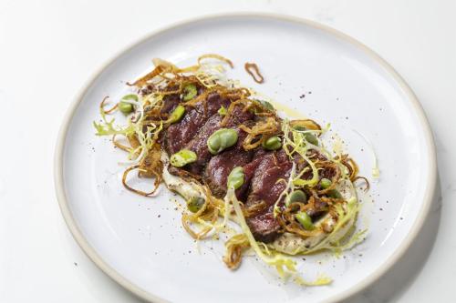 a plate of food with noodles and green onions at Holmes Hotel London in London