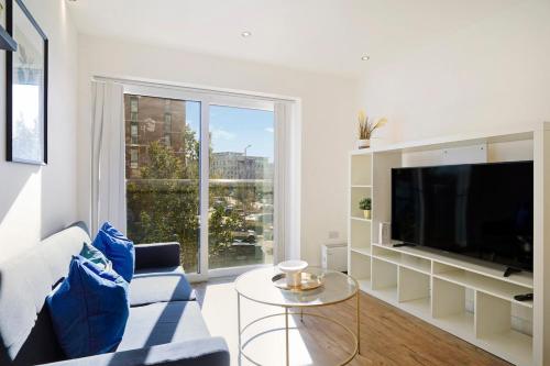 a living room with a tv and a large window at New-Build 1-Bed Apartment in Luton in Luton
