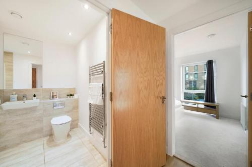 a bathroom with a toilet and a sink at New-Build 1-Bed Apartment in Luton in Luton