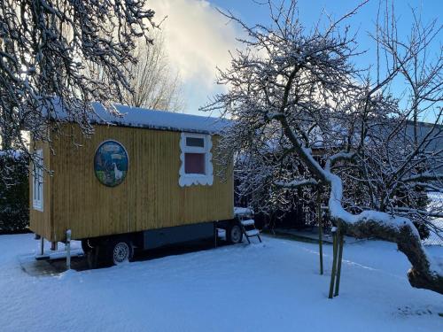 a tiny house is parked in the snow at Gypsy Caravan in Weideblick with Farm Animals in Bergen op Zoom