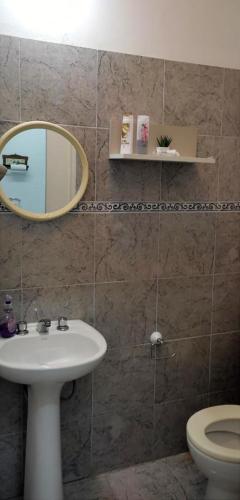 a bathroom with a sink and a mirror and a toilet at Alojamiento Mililu in Colón