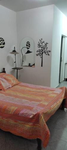 a bedroom with a bed with a tree on the wall at Alojamiento Mililu in Colón