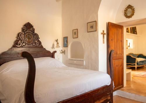 a bedroom with a large bed with a wooden headboard at Can Toni Platera in Sant Francesc Xavier
