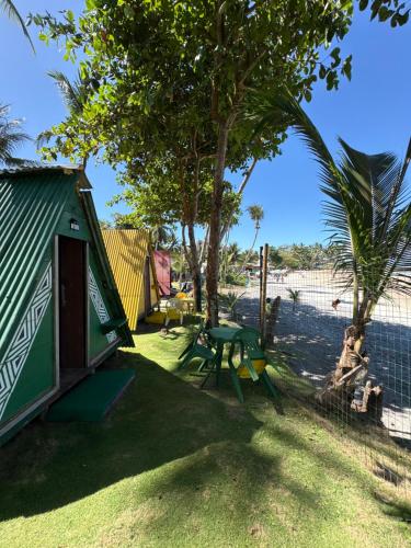 a green shack with a picnic table and a tree at Camping Gnomo Místico in Olivença