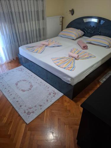 a bedroom with a bed with two pillows and a rug at Apartman - TAHRIC in Bihać