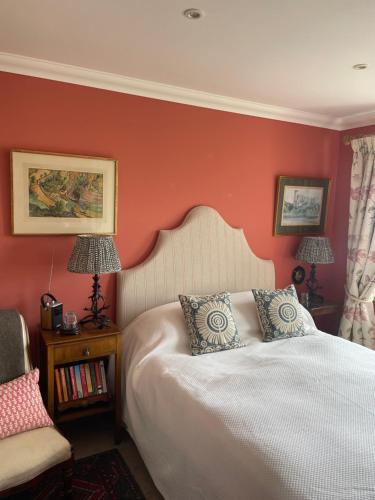 a bedroom with a white bed and a red wall at Dunvegan Steading Bed and Breakfast in Dunvegan