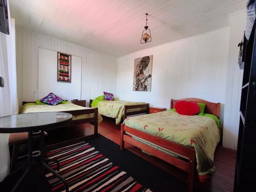 a room with two beds and a table in it at Hospedaje Luna in Valdivia