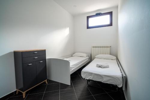 a small room with two beds and a dresser at B&B Il Trecciolino in Palmi