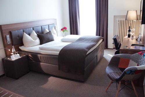 a bedroom with a bed and a desk and a chair at Schlosshotel Kassel in Kassel