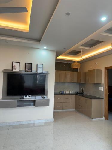 a large kitchen with a large flat screen tv at Simbas Den by Abodeandco in Dehradun