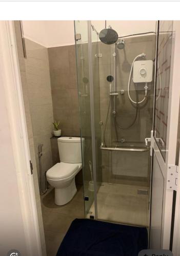 a bathroom with a toilet and a glass shower at Shelo Transit Hotel in Katunayaka