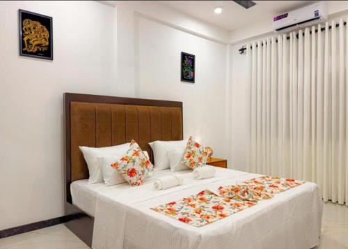a bedroom with a large white bed with flowers on it at Shelo Transit Hotel in Katunayaka