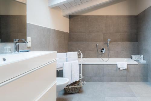 ein Badezimmer mit einer Badewanne, einem Waschbecken und einem WC in der Unterkunft Hotel garni - Chiemsee-Pension-Seebruck in Seebruck