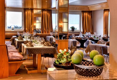 a dining room with tables and chairs and windows at Hotel Bayernwinkel - Yoga & Ayurveda in Bad Wörishofen