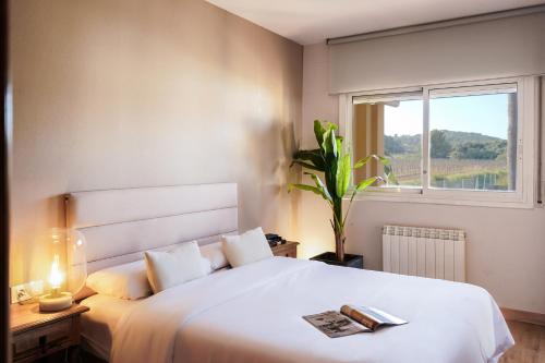 a bedroom with a large white bed with a window at Villa Rocamar by Hello Homes Sitges in Sitges