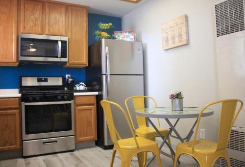 a kitchen with a table and a refrigerator at Seaside Flamingo Retreat in Oceano