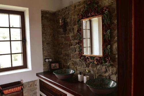 a bathroom with two sinks and a mirror at Finca La Alcolehuela in Santa Elena