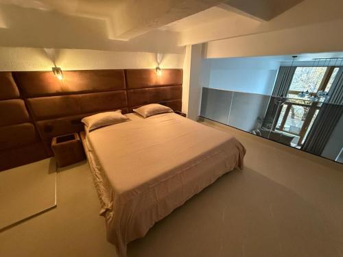 a bedroom with a bed and a large window at Infinity Loft Residence in Târgu Jiu