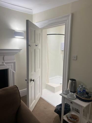 a living room with a door leading to a bathroom at Harmondsworth Hall in Harmondsworth