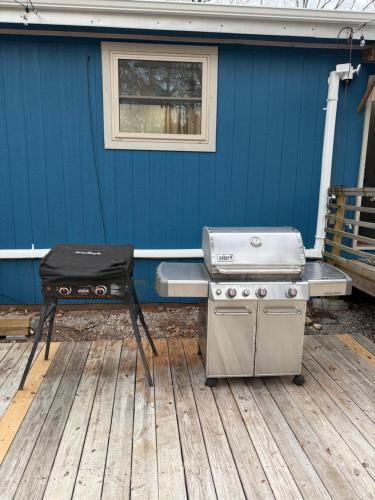 a bbq and a grill sitting on a deck at Barn Door Themed Garvan Gardens Blue Bungalow in Hot Springs