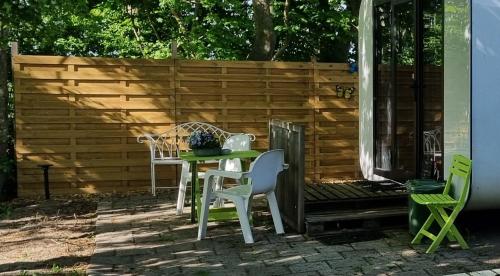 a patio with a table and chairs and a fence at City Farmer Farmyard Stays, Sleep Easy, Stay Rural, Explore Amsterdam in Amsterdam