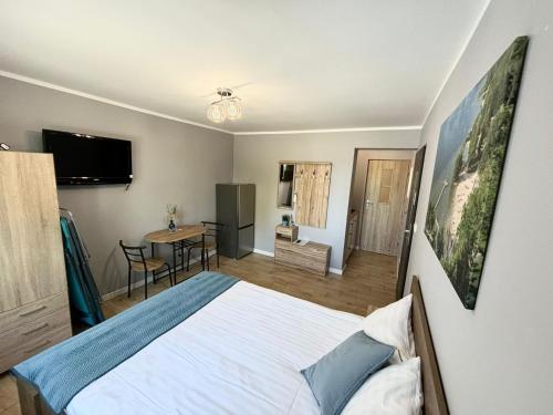a bedroom with a large bed and a table at Wczasy Boszkowo in Boszkowo