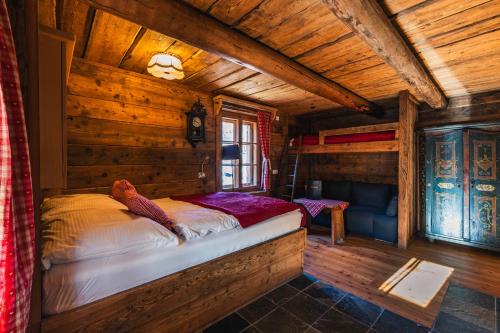 a bedroom with a bed in a log cabin at Hotel Schlosswirt in Großkirchheim