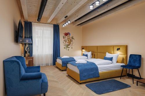 a hotel room with two beds and a chair at Oysters & Bubbles Gastro Hotel. Rynok square in Lviv