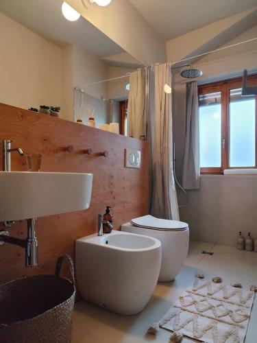 a bathroom with a white sink and a toilet at Il Faggio Rosso Apartment in Vernante