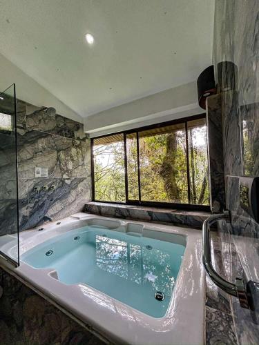 a large bath tub in a room with a window at Casa Tucan Glamping in Turrialba