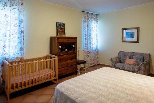 a bedroom with a crib and a chair and a chair at Villa Marchetti in Cupra Marittima