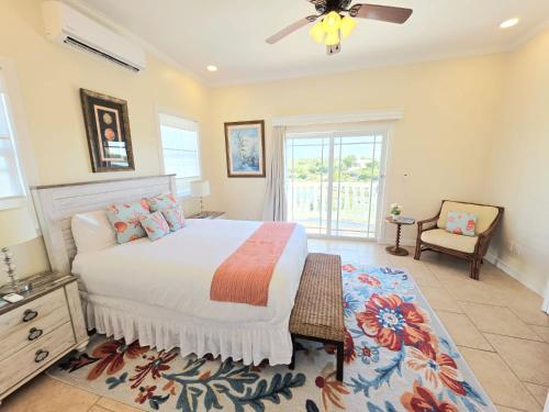 a bedroom with a bed and a ceiling fan at The Babbington Villa in Taylor Bay Beach