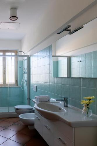 a bathroom with a sink and a toilet and a mirror at Villa Marchetti in Cupra Marittima