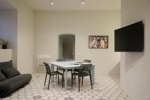 a living room with a table and chairs and a couch at Viaggio Homes Appartamenti da 60 m2 con Jacuzzi Hammam Cucina Patio con Aperitivo di Benvenuto in Faiano