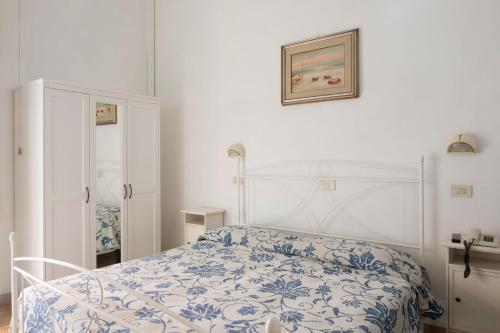 a bedroom with a bed with a blue and white bedspread at Hotel Torre in Viareggio