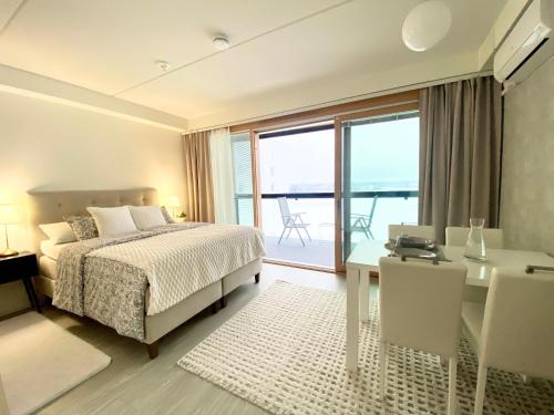 a bedroom with a bed and a desk and a balcony at Sky Studio - free parking and lake view in Jyväskylä