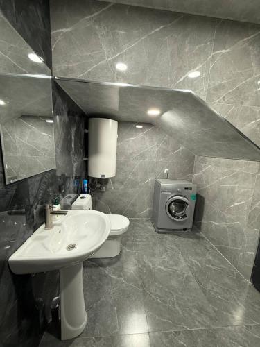 a bathroom with a sink and a toilet and a tv at Elen Apartment Goris in Goris