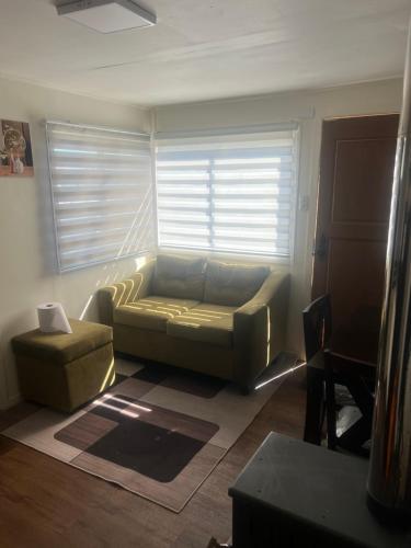 a living room with a couch and a chair at CASA DEL CENTRo in Quellón
