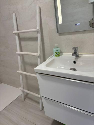 a bathroom with a white sink and a wooden ladder at Ap. con piscina, Moraira centro. in Moraira