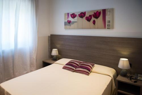 a bedroom with a bed with two pillows on it at Albergo Grappolo D'oro in Montebelluna