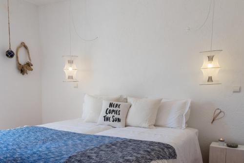 a white bedroom with a bed with two pillows at Utopia in Aljezur