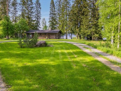 a log cabin in the middle of a green field at Holiday Home Kelo-kolo by Interhome in Iisalmi