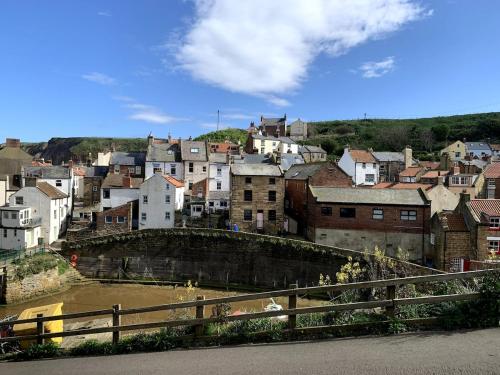 a city with a bridge over a river with buildings at Fisherman's Cottage, Staithes in Staithes