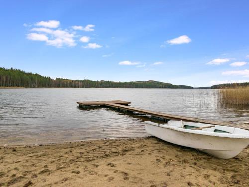a boat sitting on the beach next to a dock at Holiday Home Koskiharju by Interhome in Säynetlahti