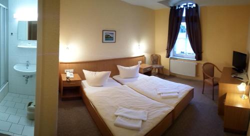 a hotel room with a bed and a bathroom at Hotel Schützenhaus in Bad Düben