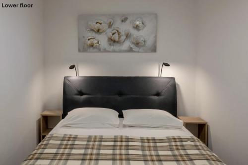 a bed with a black headboard in a bedroom at Casa Romina in Višnjan