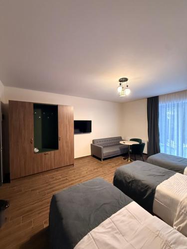 a hotel room with two beds and a flat screen tv at Gоderdzi Twins Hotel in Goderdzi