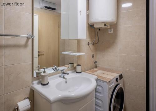 a bathroom with a sink and a washing machine at Casa Romina in Višnjan