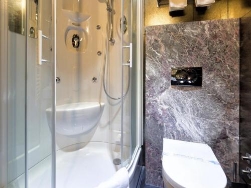 a bathroom with a shower and a toilet at Nova City Garni Hotel Signature Collection in Belgrade