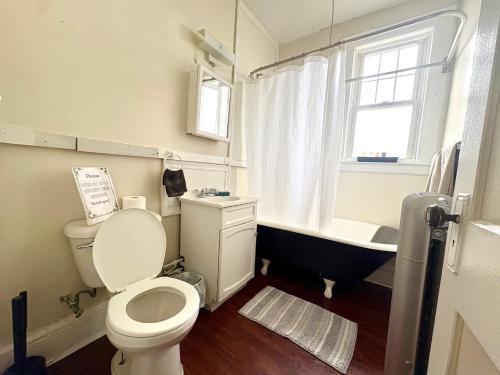 a bathroom with a toilet and a bath tub at The Wadsworth Suite A2 in Hartford